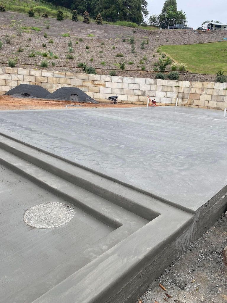 A large concrete slab is sitting on top of a dirt field.