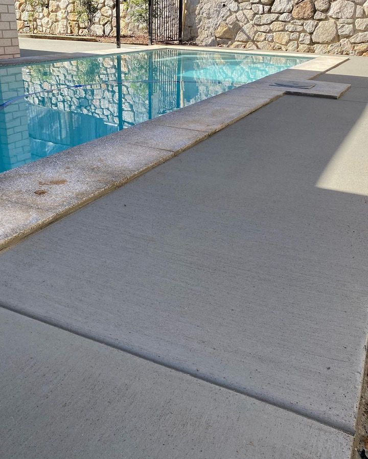 A swimming pool with a stone wall in the background
