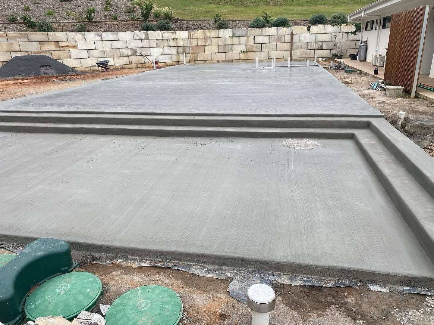 A concrete floor is being built in a backyard.