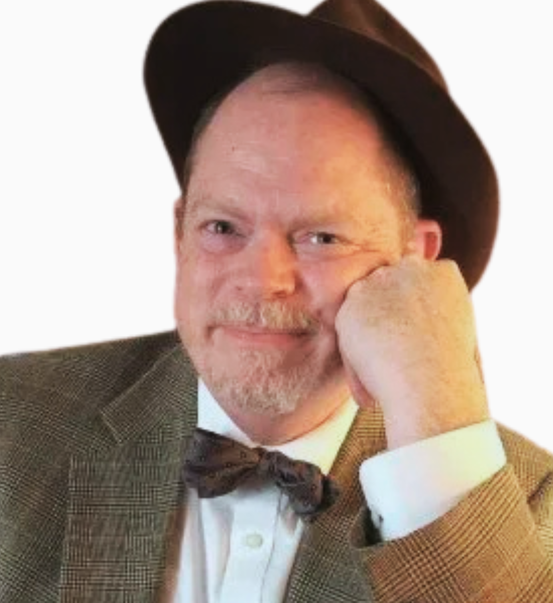 A person wearing a brown fedora, a tweed blazer, and a bow tie, resting their chin on their hand against a white background.