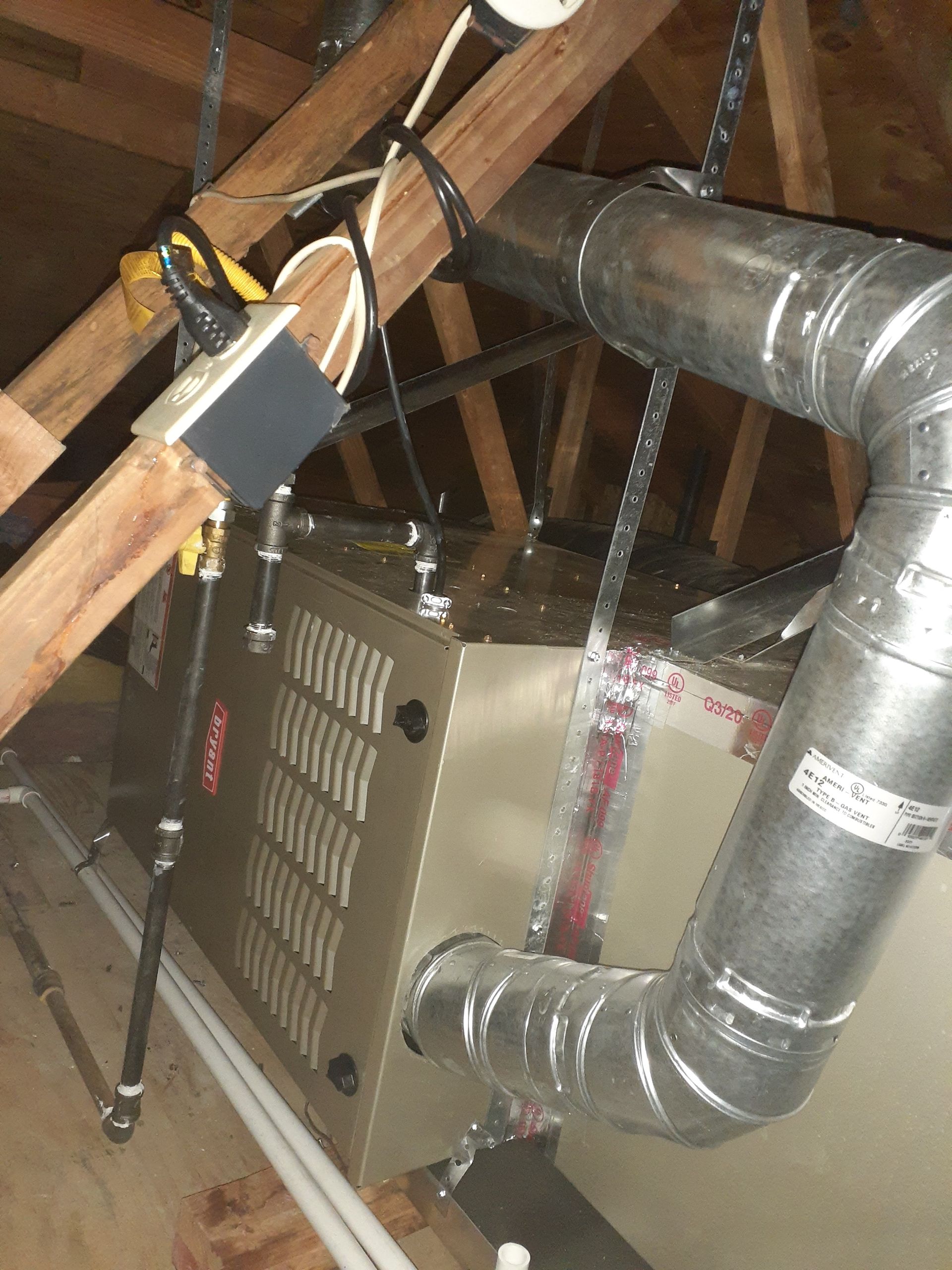 Attic HVAC unit with metal ductwork and exposed wooden rafters
