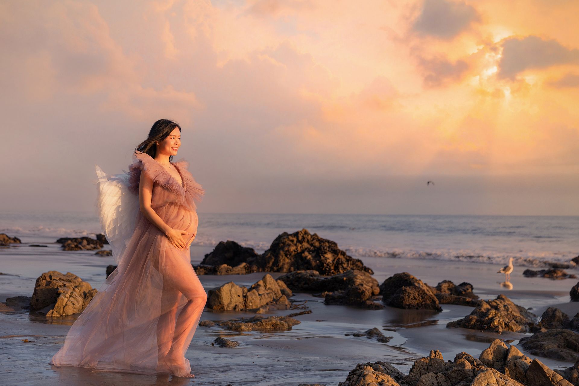 maternity woman stands on El Matador Beach. 