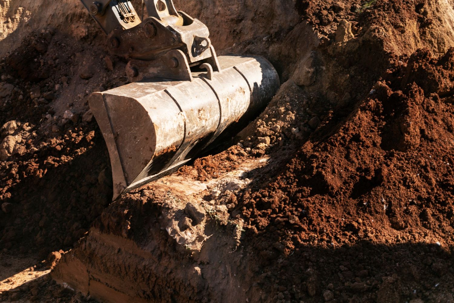 A bulldozer is digging in a pile of dirt