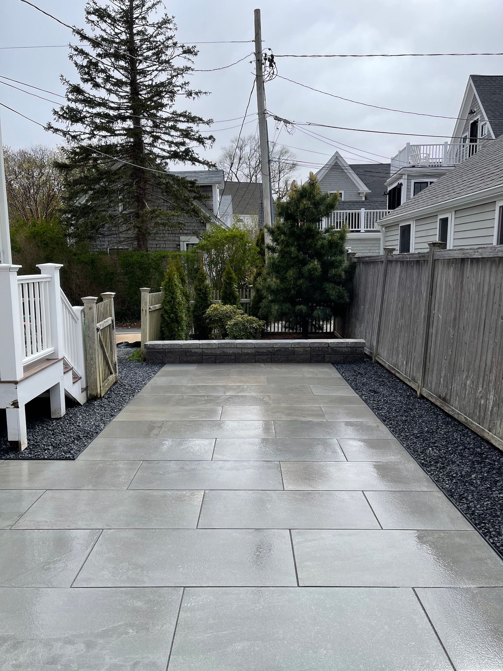 A concrete driveway leading to a house with a white railing