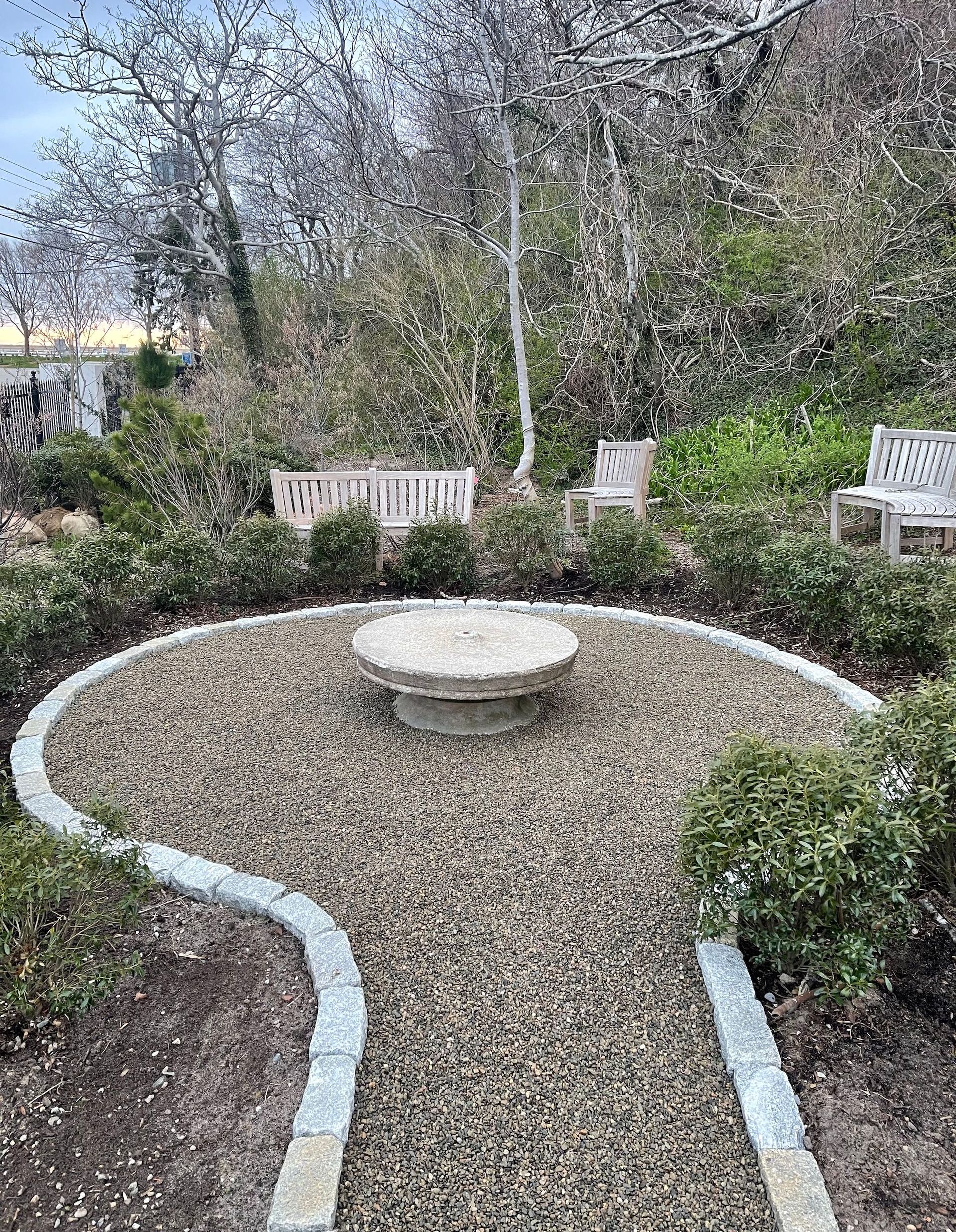 There is a fire pit in the middle of the garden.