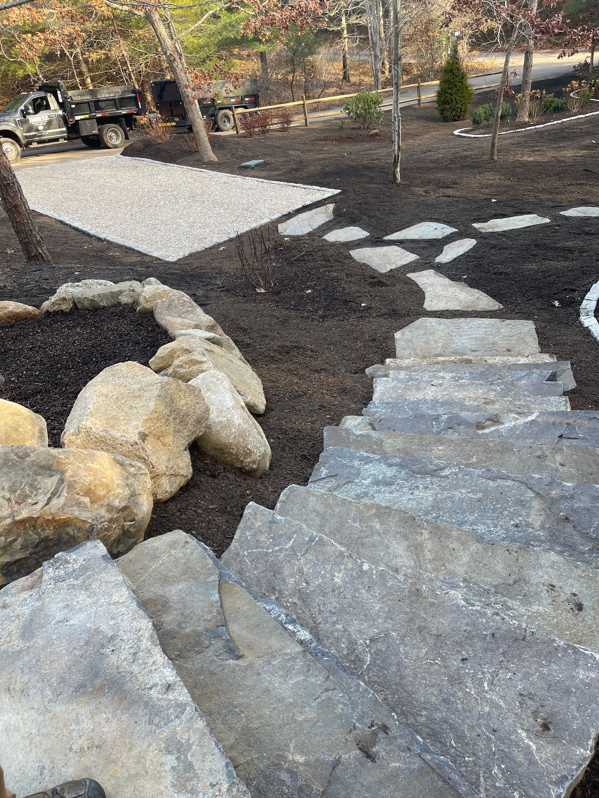A stone walkway leading to a fire pit in a backyard.
