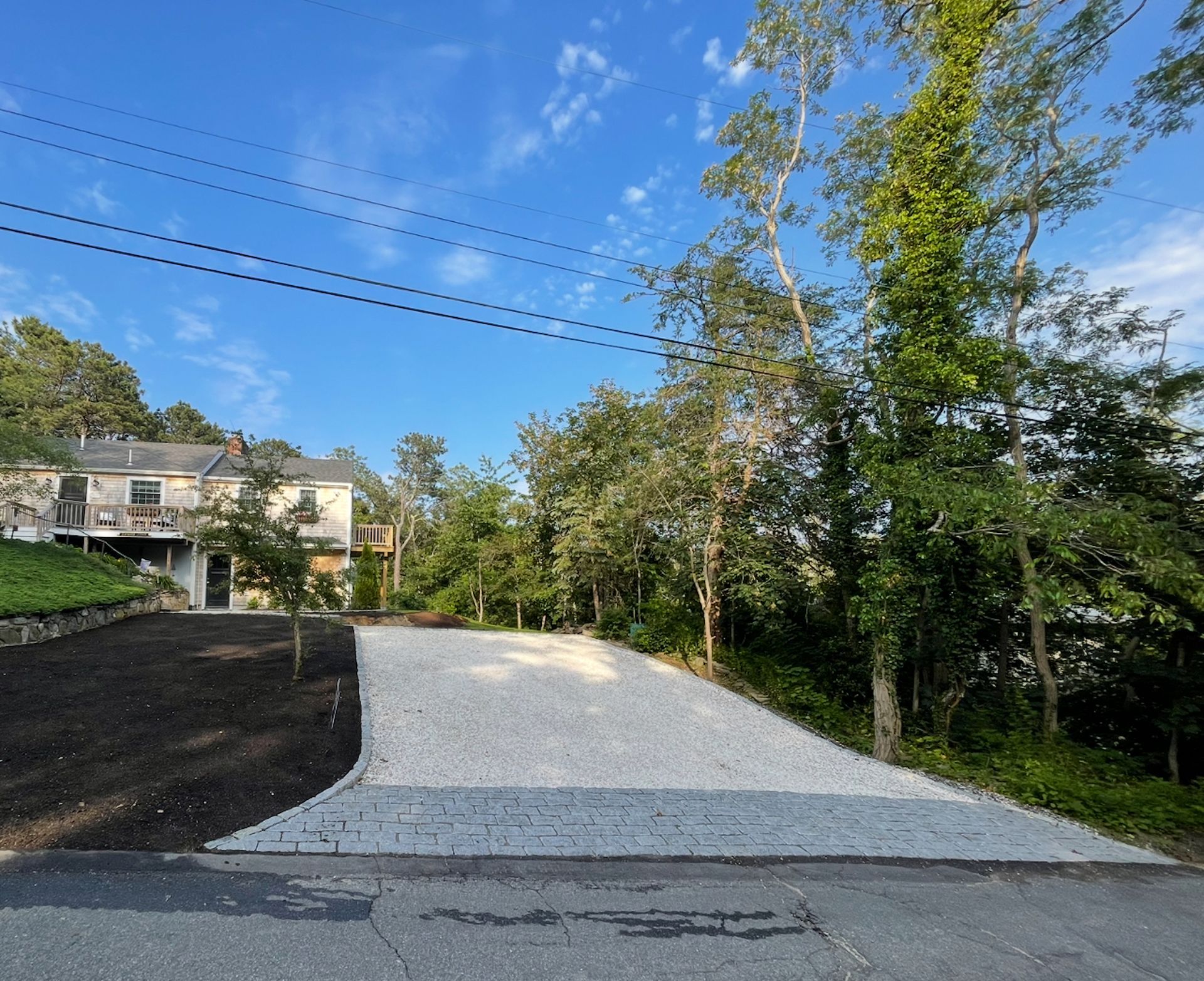 A gravel driveway with a house in the background
