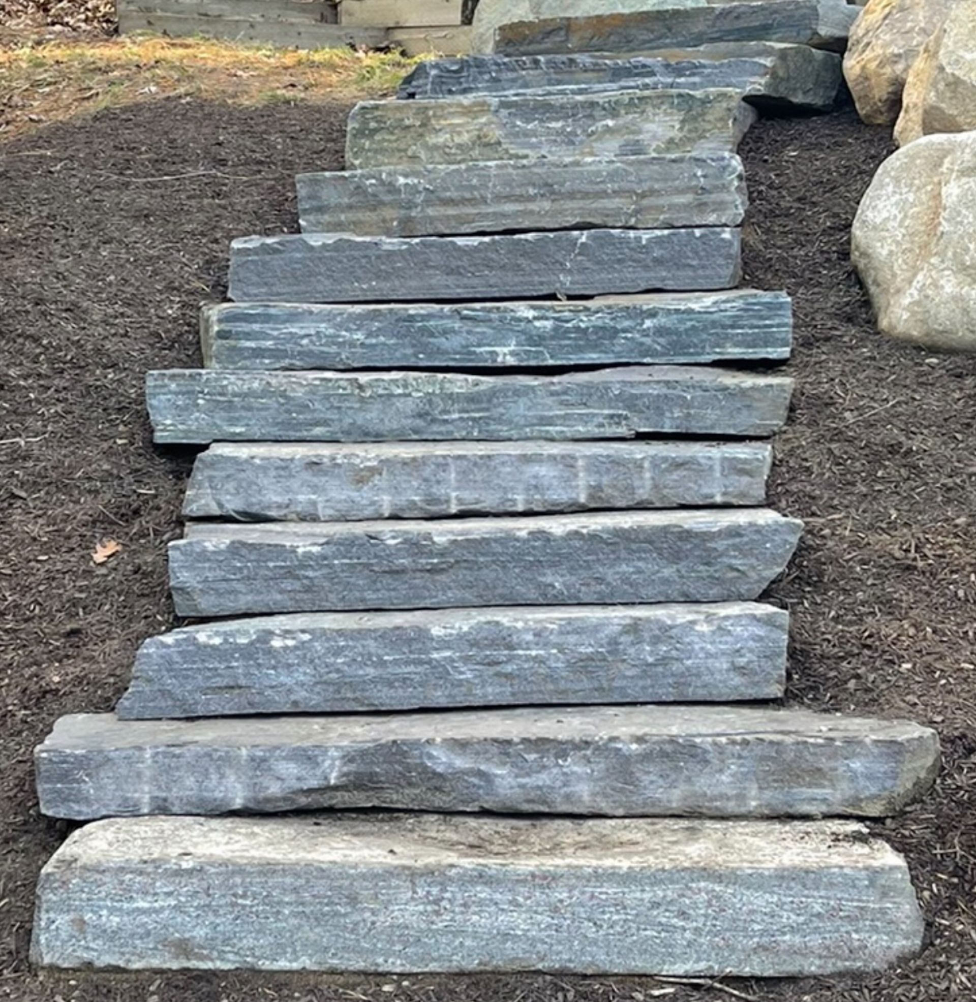 A row of stone steps leading up to a rock wall