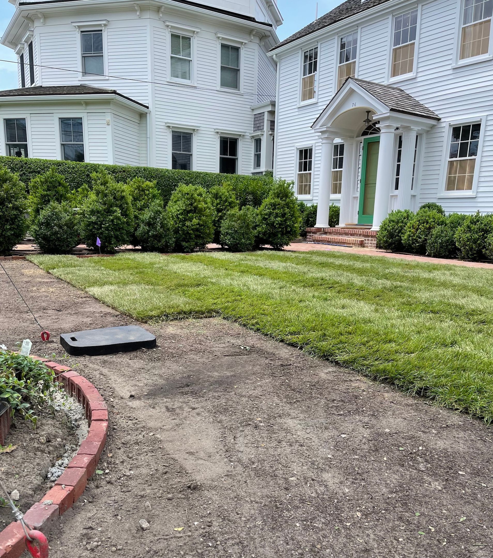A large white house with a lush green lawn in front of it.