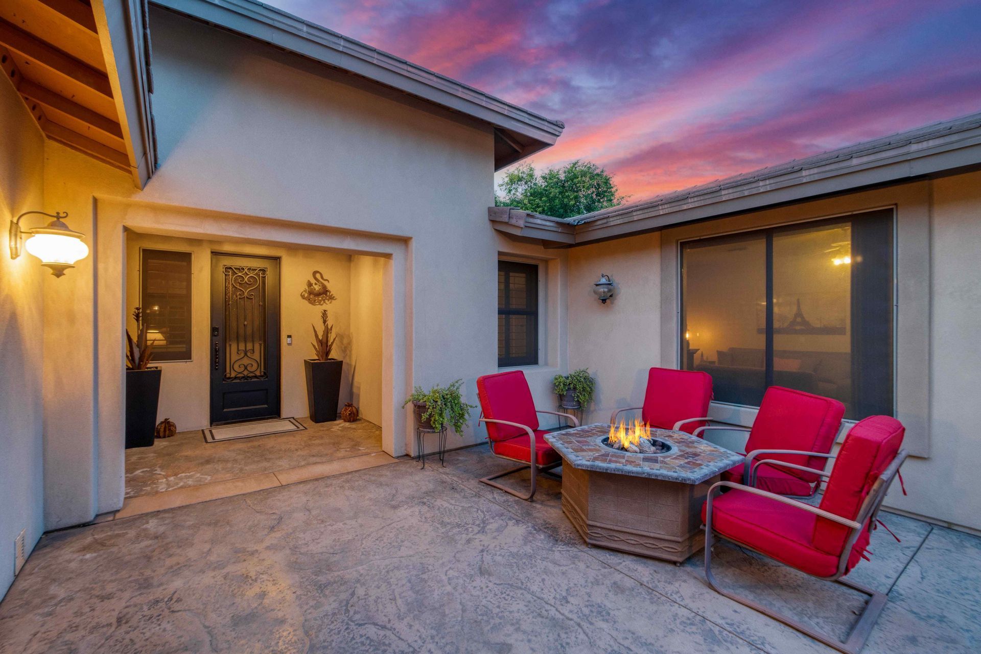 An outdoor living space with chairs surrounding a fire