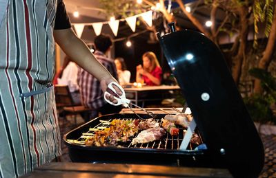 A Man Grilling Food At A BBQ Island