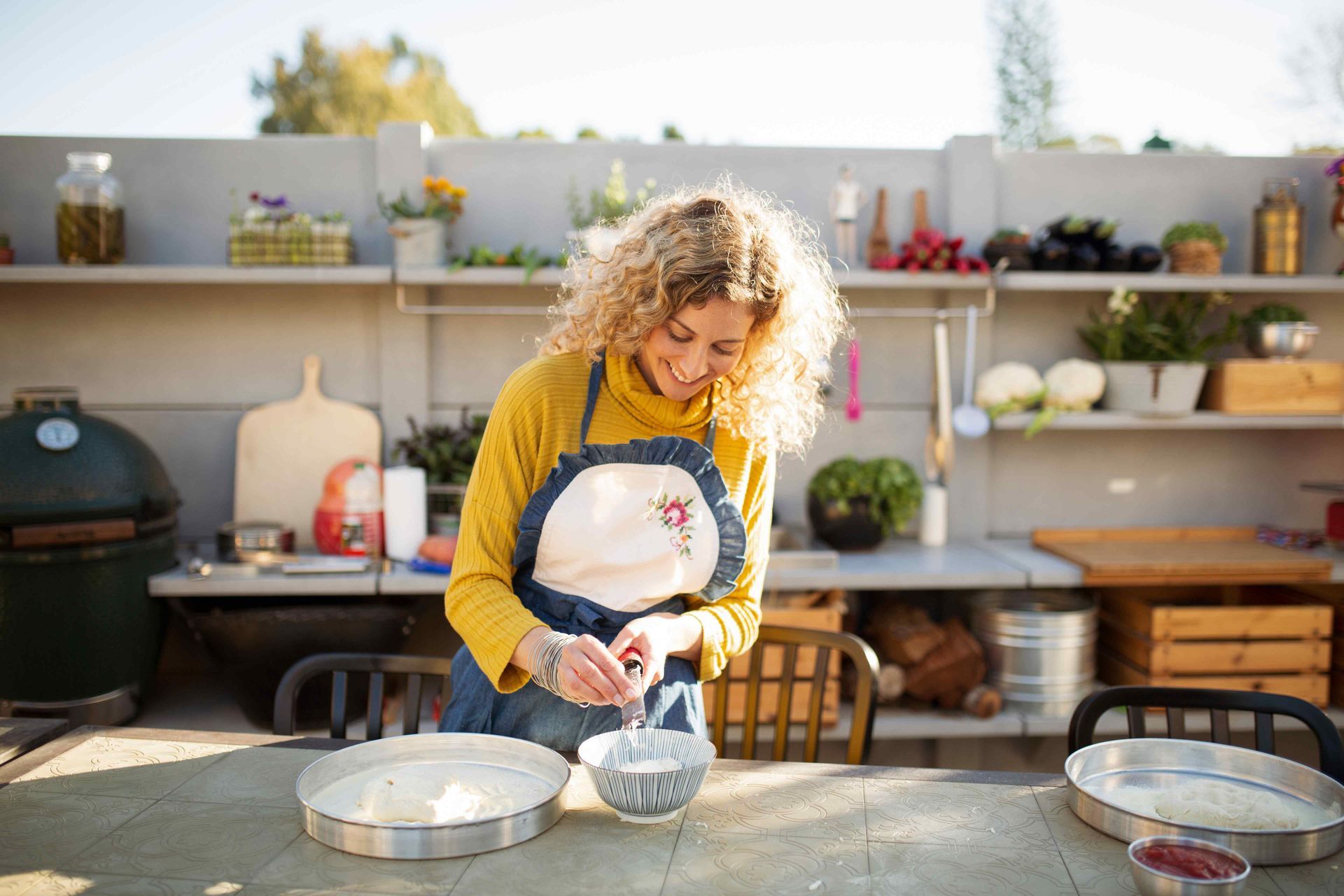 A woman preparing food in an outdoor kitchen
