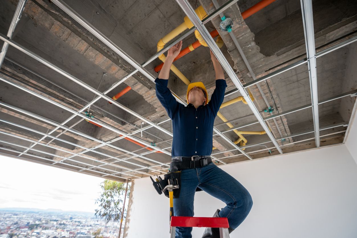 A plumber inspecting pipes during the rough-in plumbing installation process