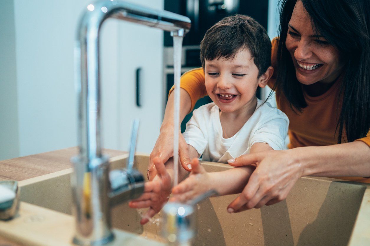 Mother and child in the kitchen, showing efficient well water supply.