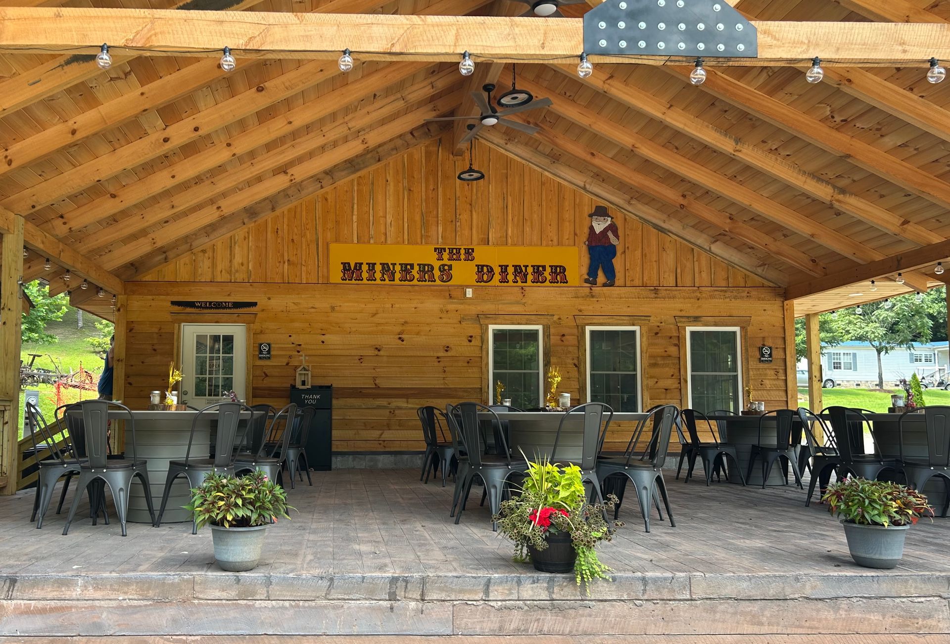 A picnic area in front of a building with a sign that says ' the muddy moose ' on it