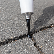 Crack filler being poured into a pavement crack