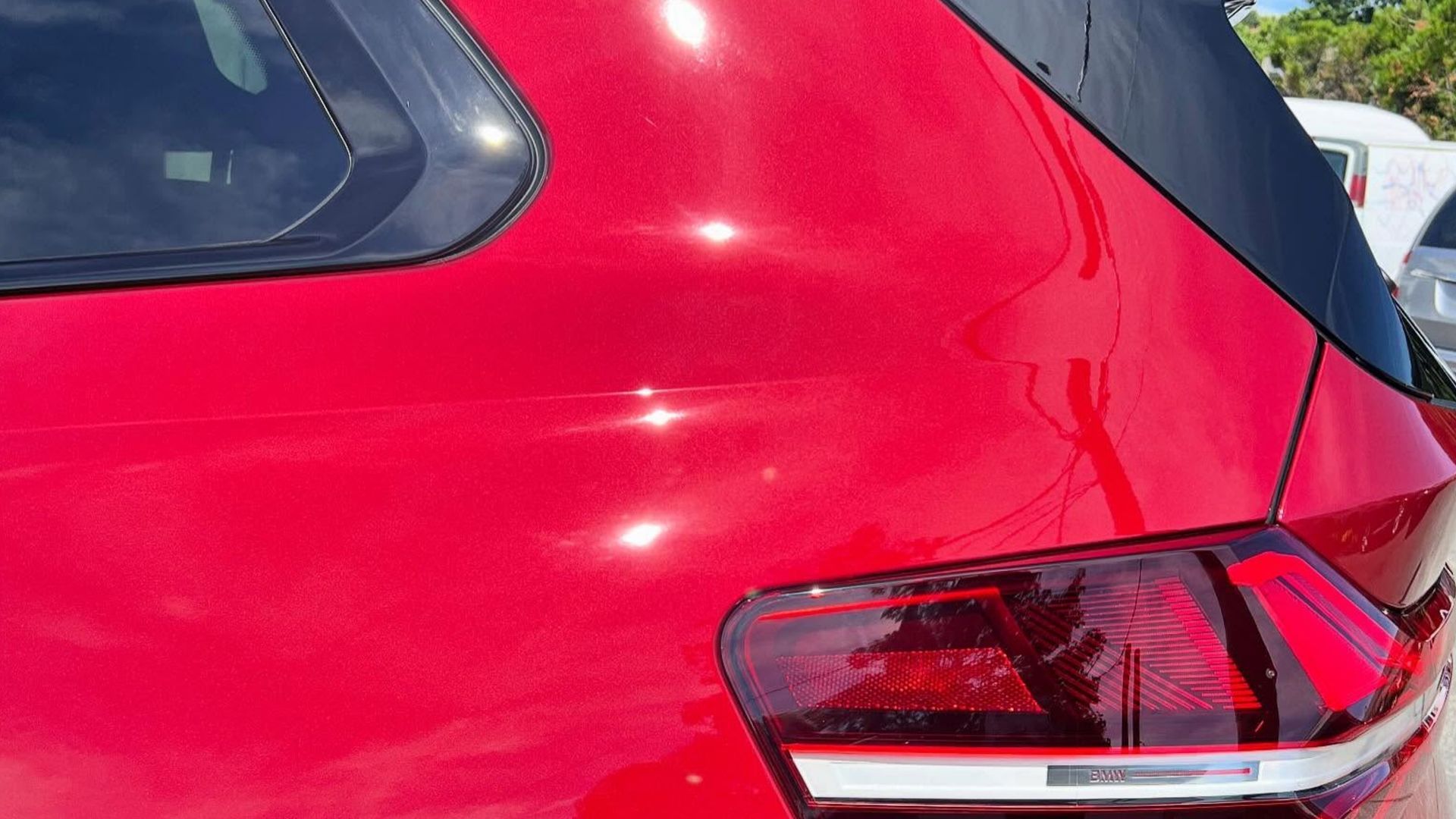 Rear side of a bright red SUV with tinted windows and a visible taillight