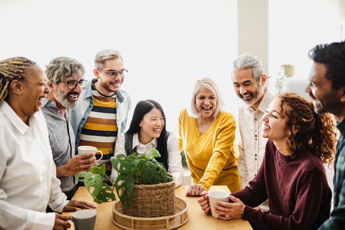 A group of people are sitting around a table drinking coffee.
