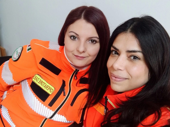 I paramedici caricano un uomo in sedia a rotelle su un'ambulanza bianca con segnaletica rossa.