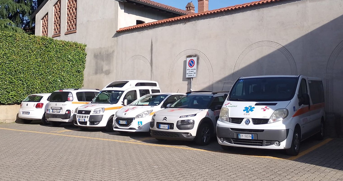 Un paramedico si prende cura di un paziente su una barella all'interno di un'ambulanza, con attrezzature mediche e finestrini che offrono una vista sulla città.