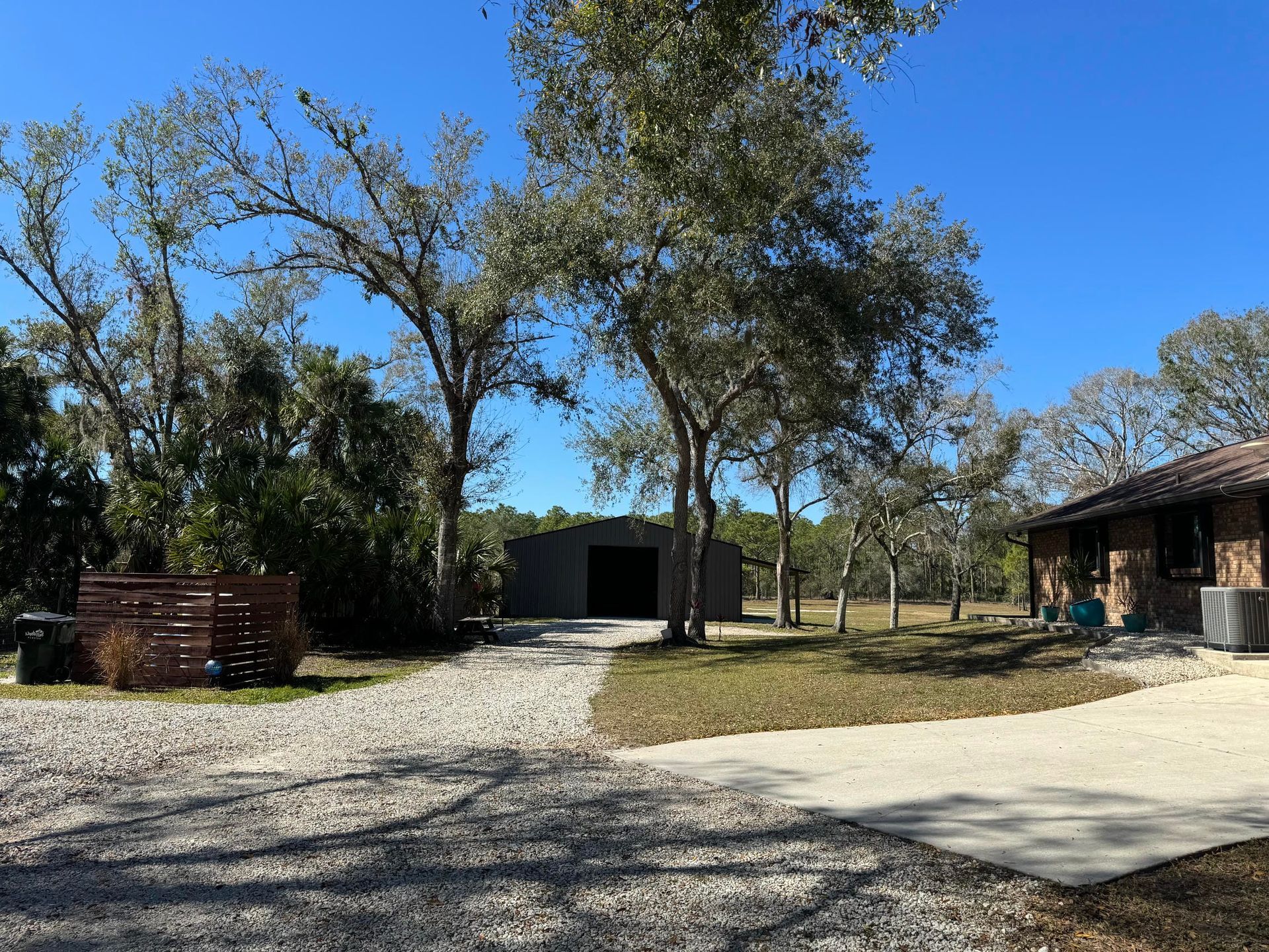 Large unfinished metal garage with exposed framing and a utility vehicle parked on the left.