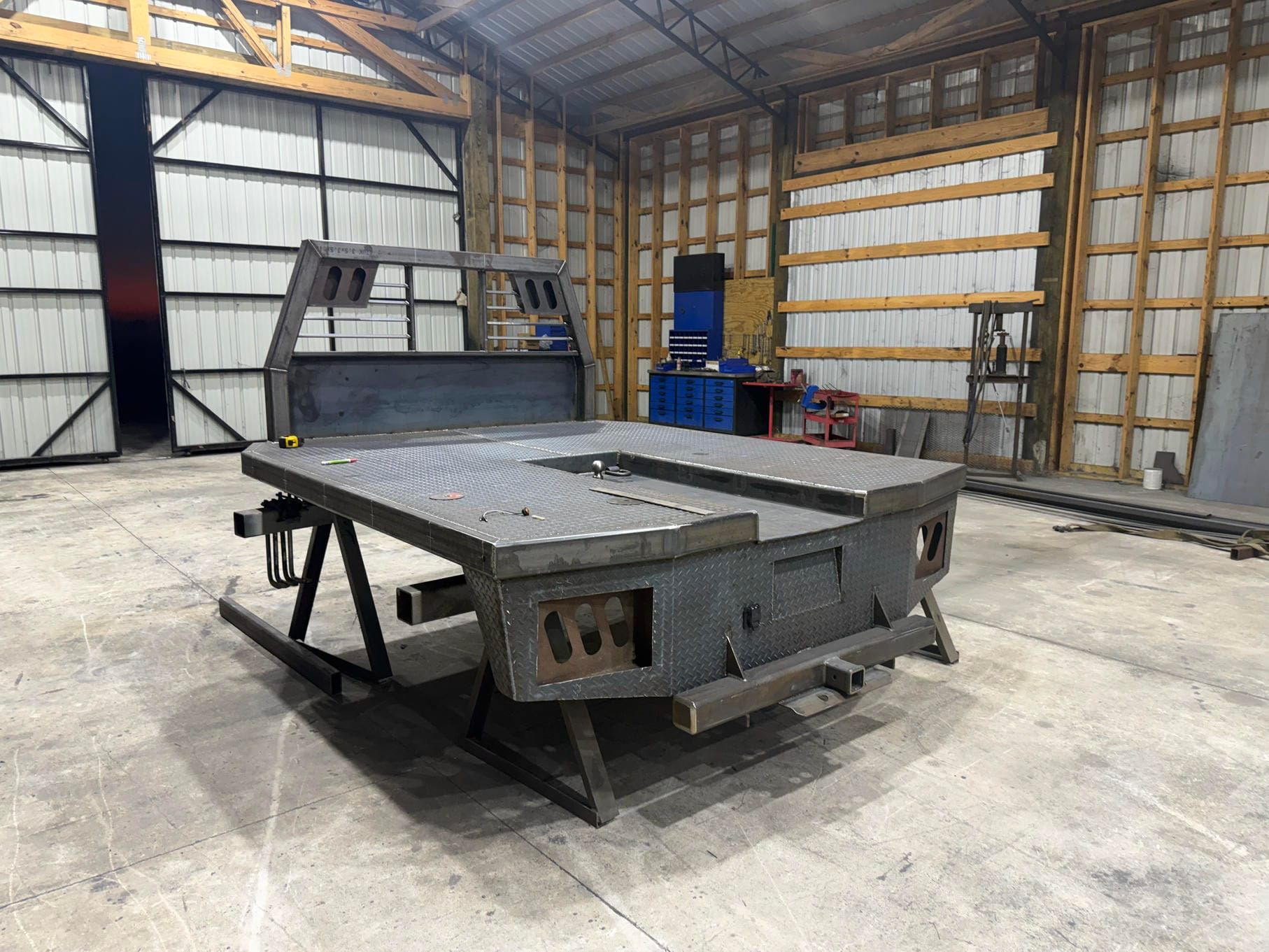Large gray industrial metal table in a warehouse workshop with concrete floor and steel-framed walls