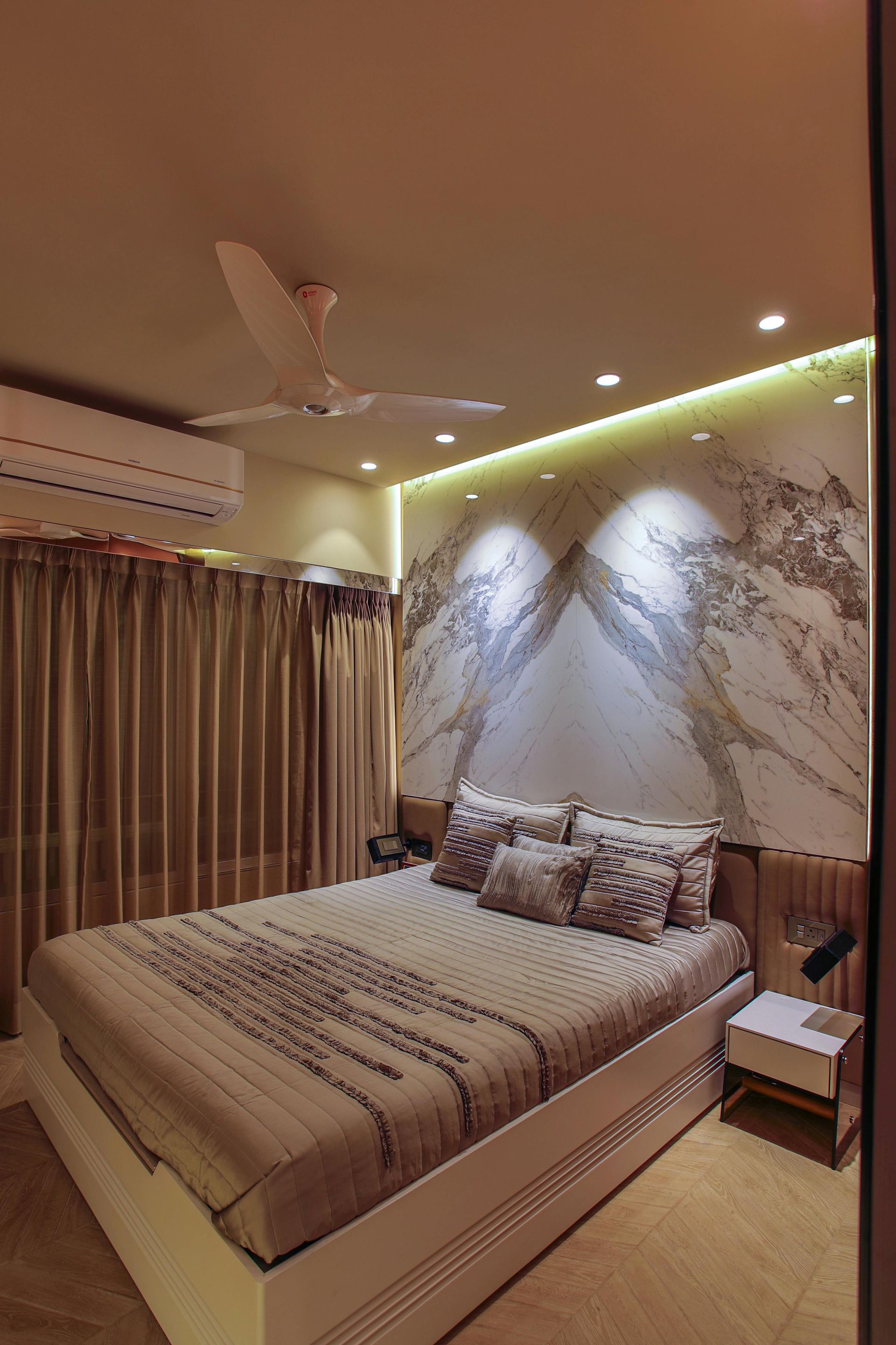 Cozy bedroom with a queen bed, patterned wall, curtains, ceiling fan, and warm recessed lighting