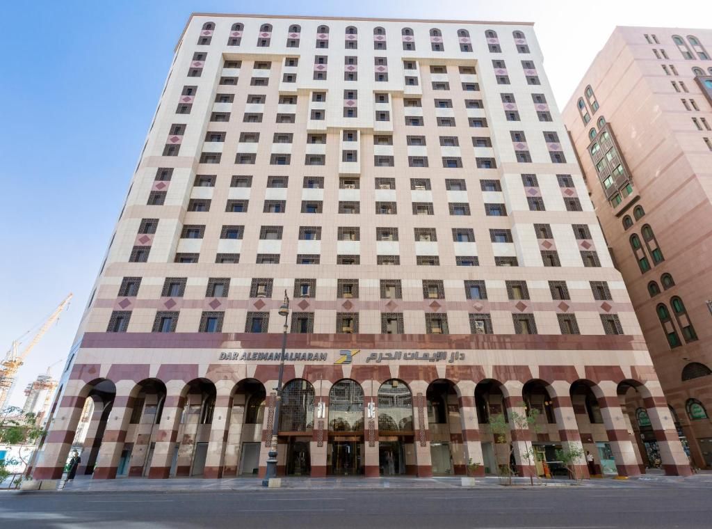 Hotel Al-Ghurfah, beige high-rise with arched entrance and many windows in Medina, Saudi Arabia.