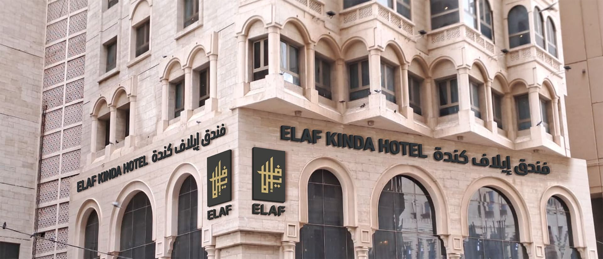 Elaf Kinda Hotel building exterior with arched windows and signage in English and Arabic.