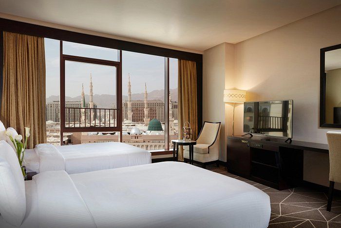 Hotel room with two beds, city view including a green dome.