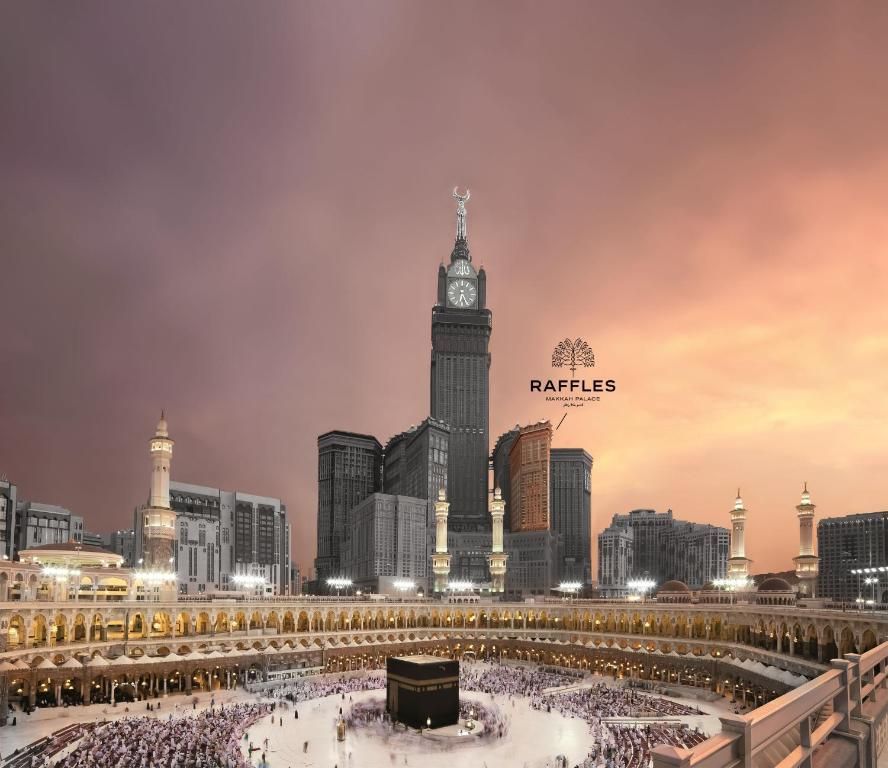 Kaaba in Mecca with clock tower and Raffles hotel, surrounded by pilgrims, dusk sky.