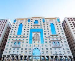 Mövenpick Madinah Hotel exterior, a multi-story building with beige and blue accents under a clear sky.