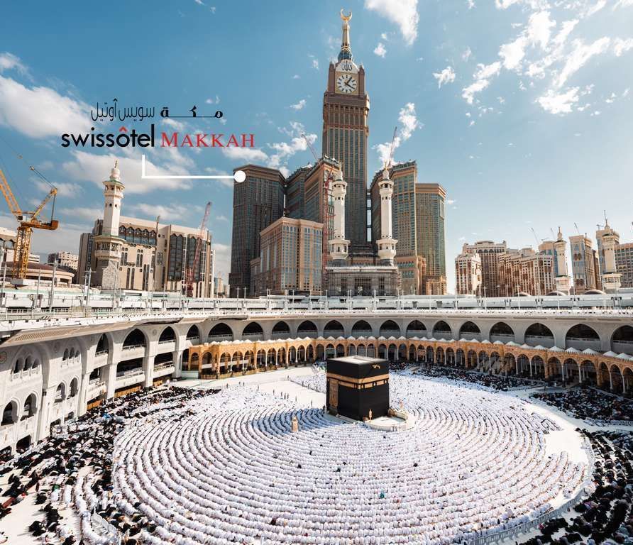 The Kaaba in Mecca, Saudi Arabia, surrounded by pilgrims. The Swissotel Makkah is in the background.