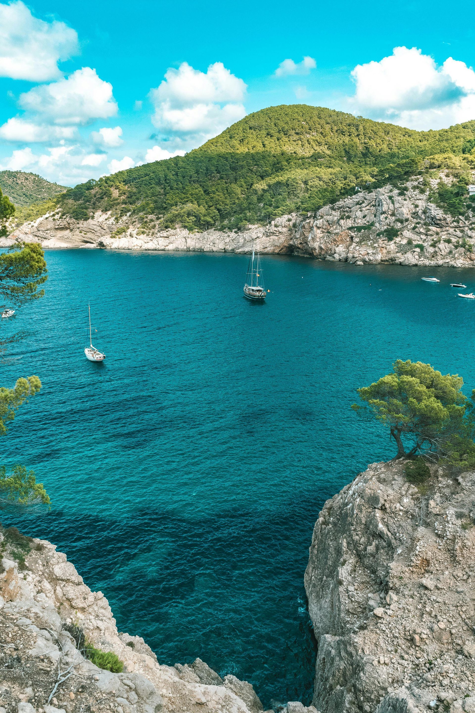 A boat is floating on top of a large body of water surrounded by mountains.
