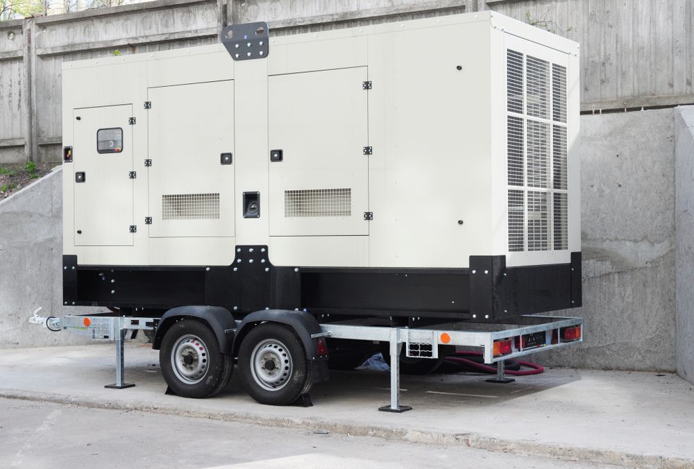 White Generator on a Trailer With Black Trim, Parked on Concrete — A.M.D. Automotive Services in Mackay, QLD