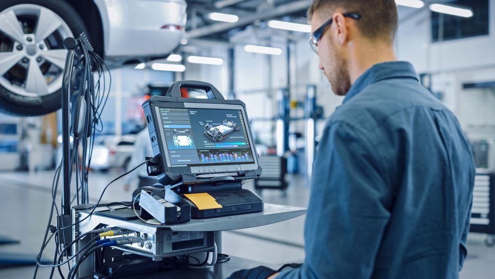 Mechanic Using Diagnostic Computer to Repair a Car in a Shop — A.M.D. Automotive Services in Mackay, QLD
