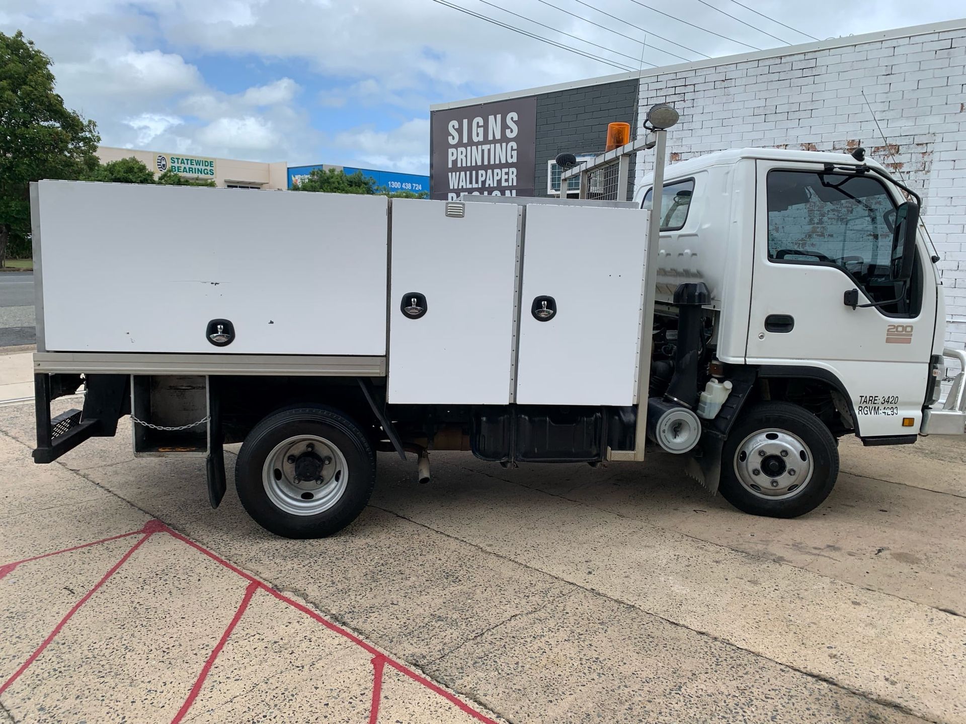 White Work Truck Parked Next to a Building — A.M.D. Automotive Services in Mackay, QLD