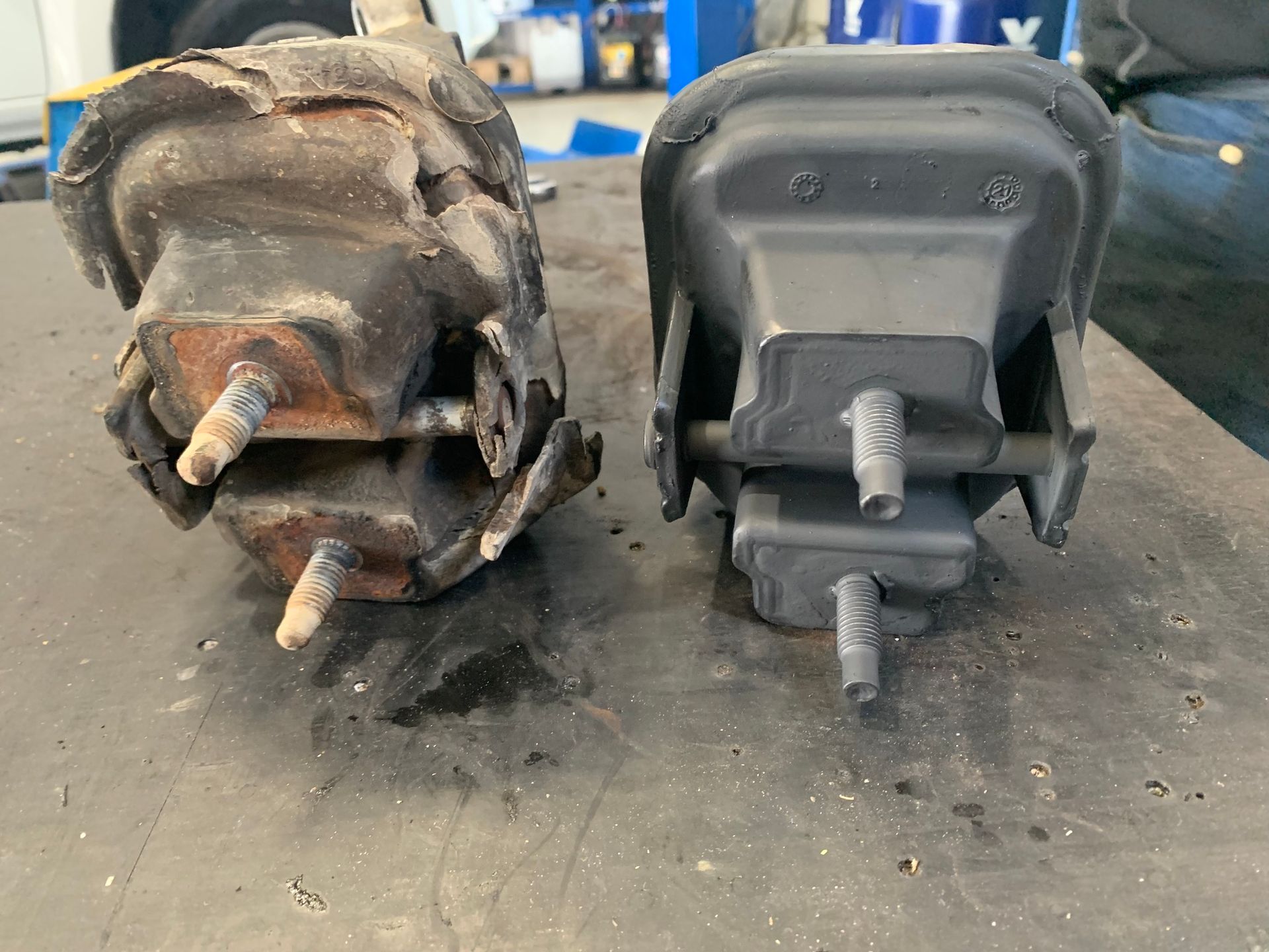 Comparison of a Worn and New Black Engine Mount on a Workbench — A.M.D. Automotive Services in Bowen, QLD