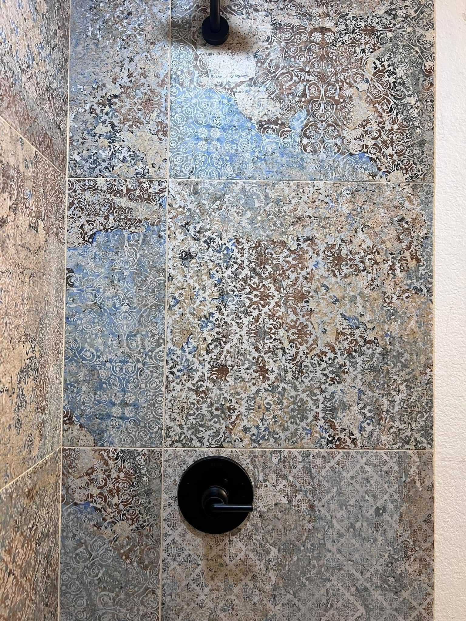 Speckled stone surface with two dark circular fixtures and a light rectangular patch near the top
