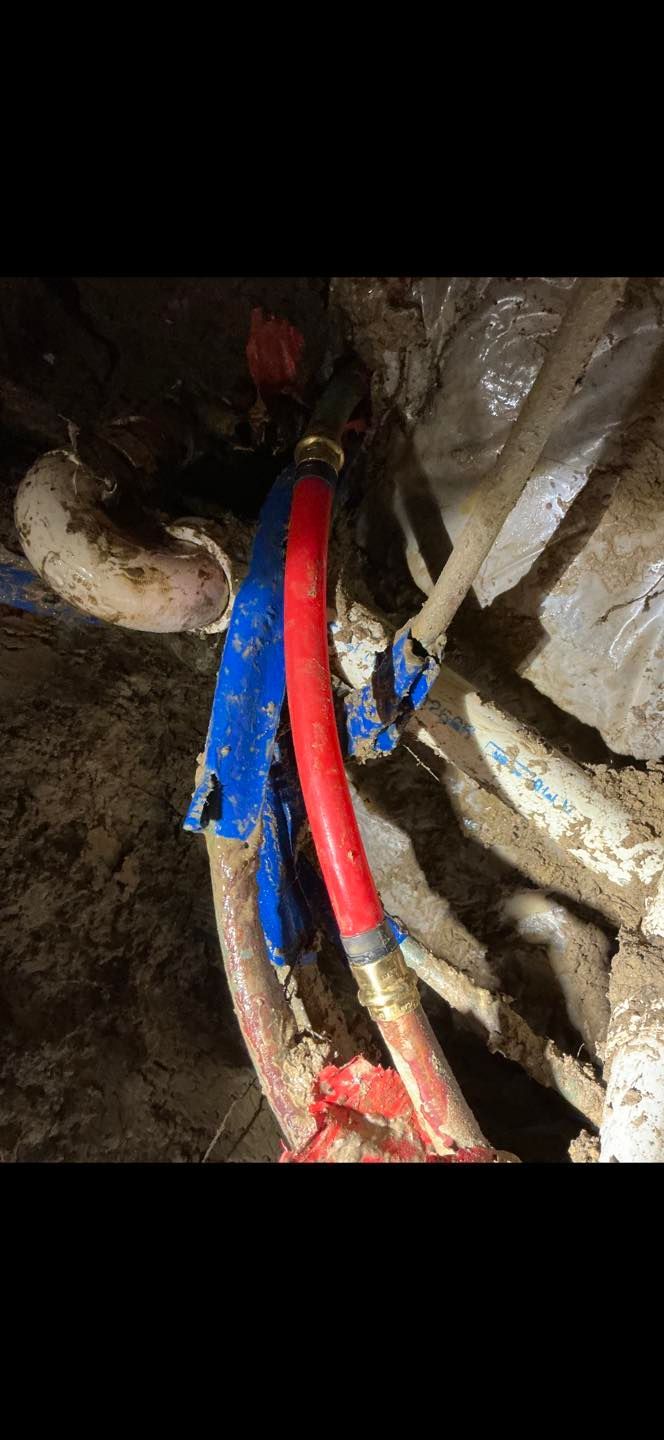 Red and blue cables running through a rocky crevice, with a small connector attached.