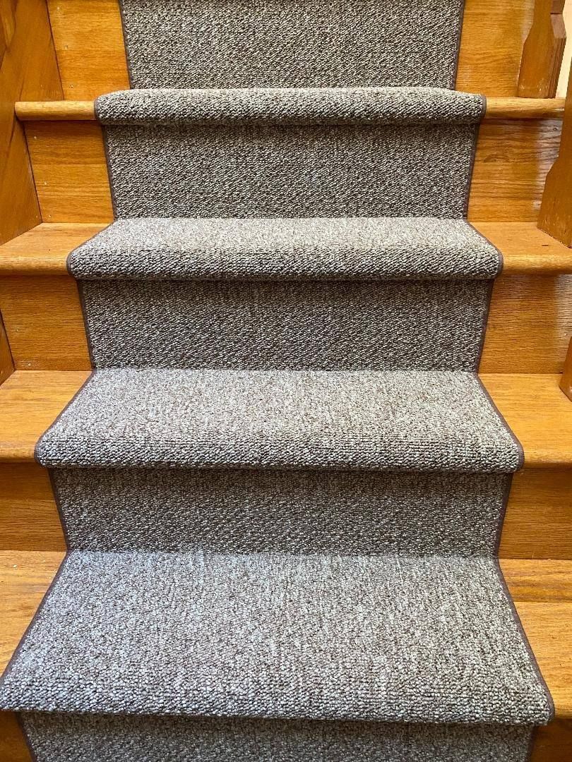 A close up of a set of stairs with a carpet on them.