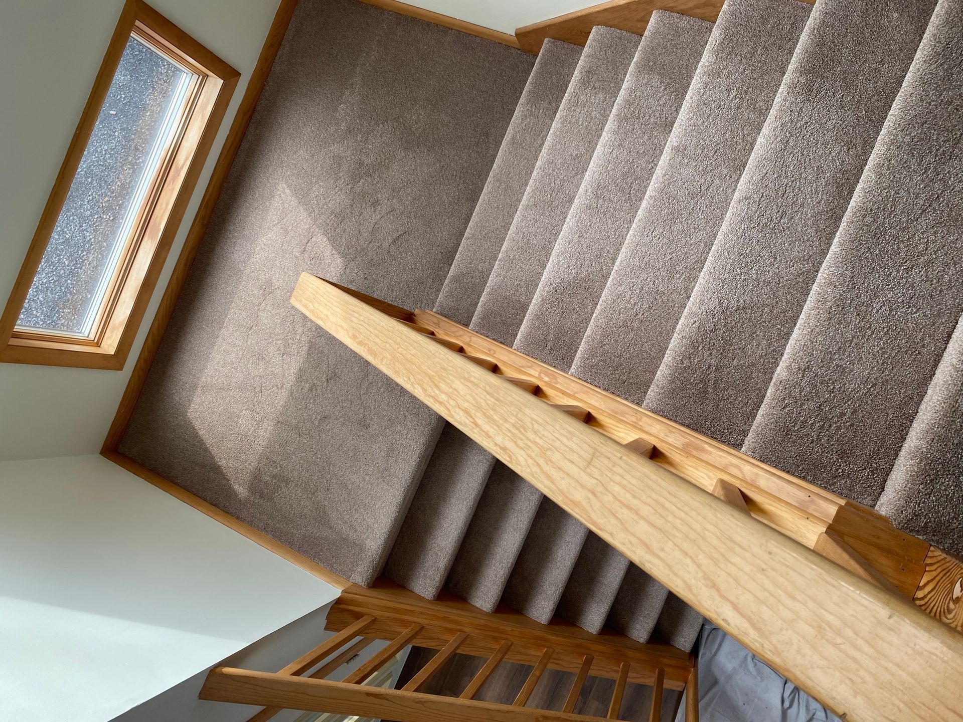A staircase with carpeted steps and a wooden railing