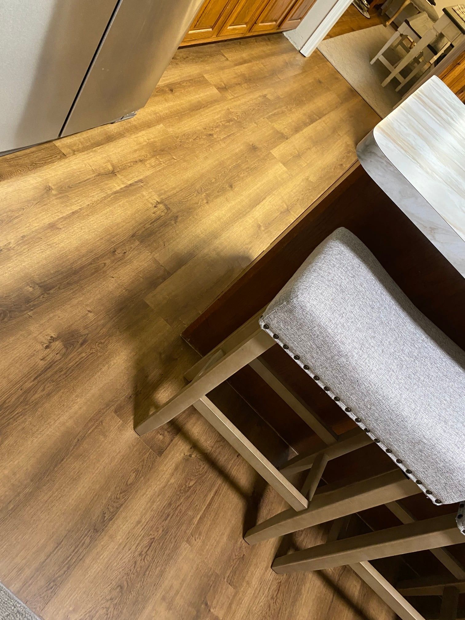 A wooden floor with a bench and a table in a kitchen.