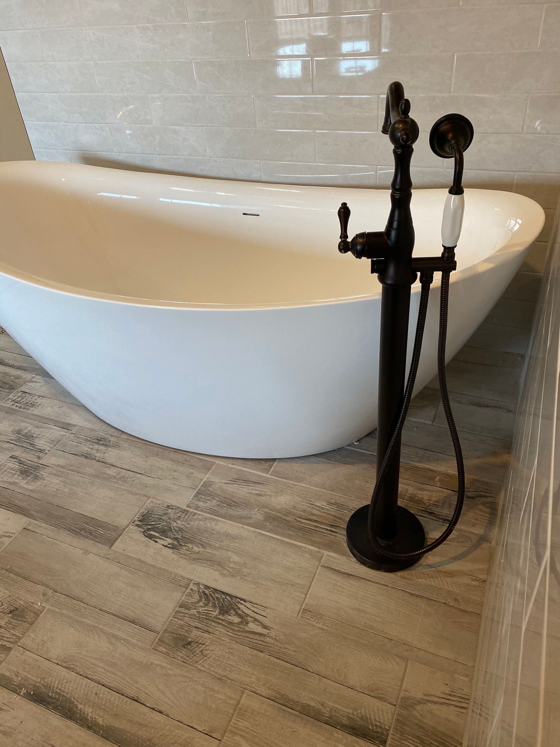 A white bathtub with a black faucet in a bathroom