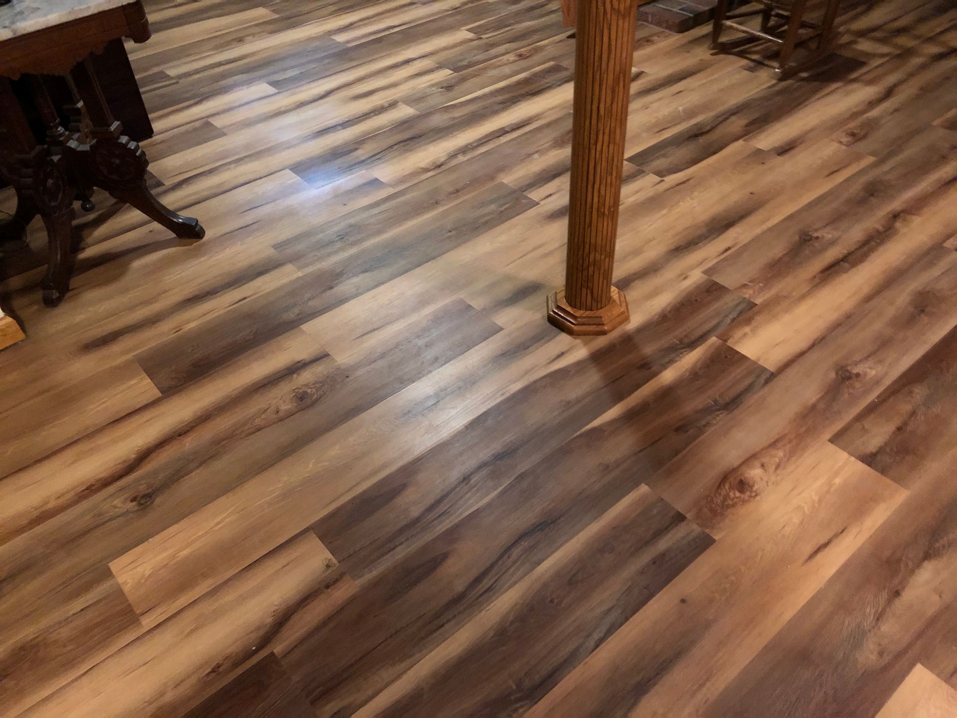 A wooden floor in a room with a table and chairs.