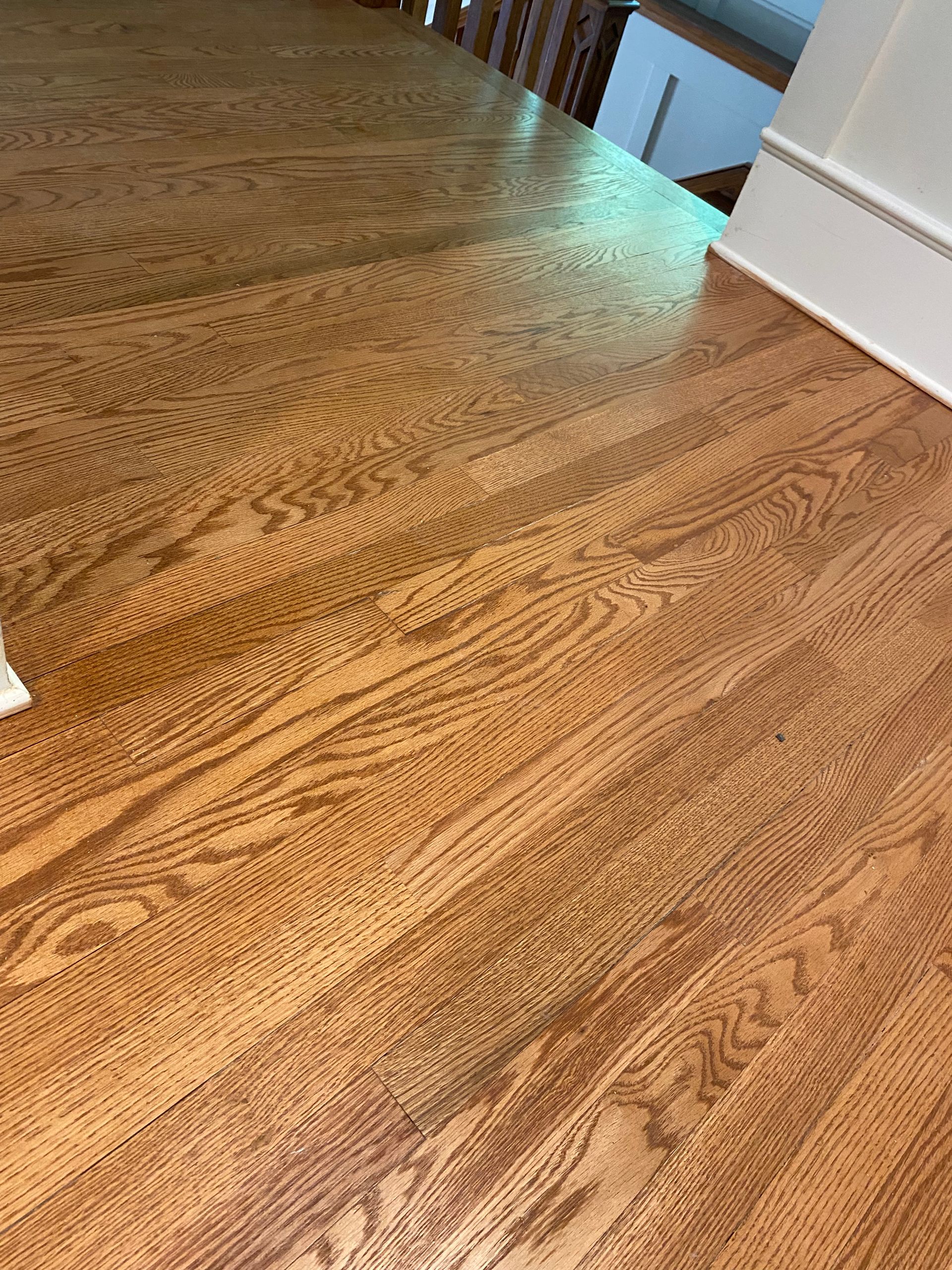 A close up of a wooden floor next to a staircase.