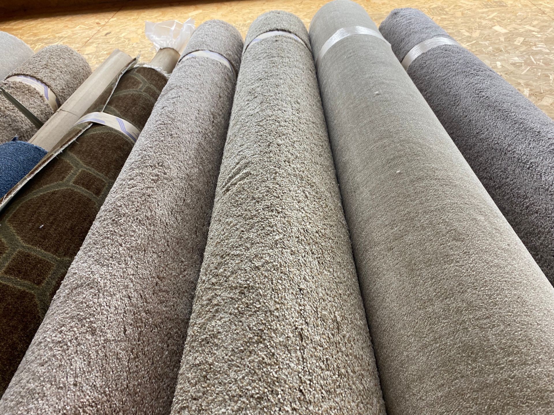 A bunch of carpets are stacked on top of each other on a table.