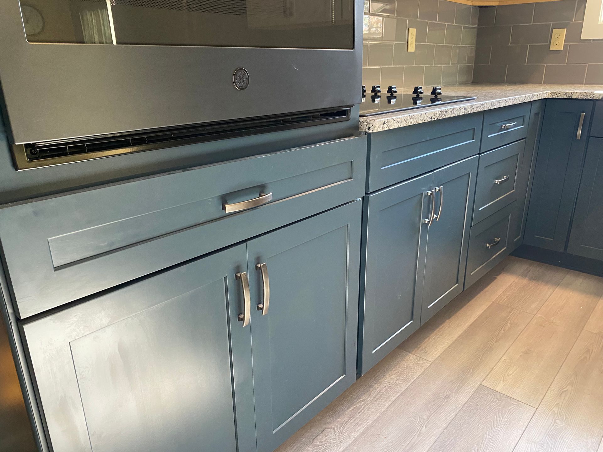 A kitchen with blue cabinets and a stove top oven