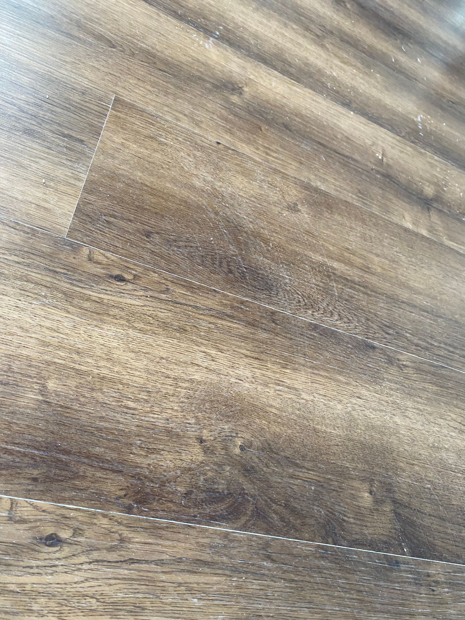 A close up of a wooden floor with a few spots on it.