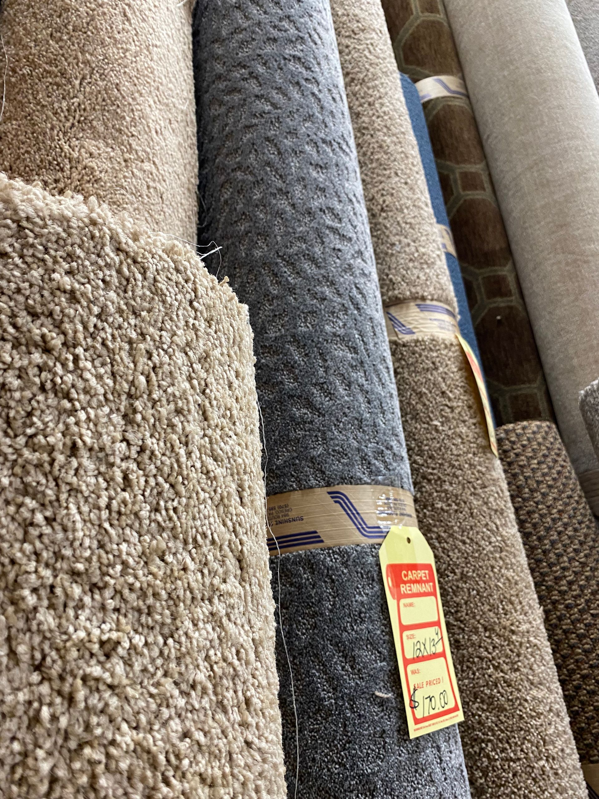 A bunch of carpets are stacked on top of each other in a store.